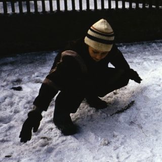Two children playing in fresh snow.