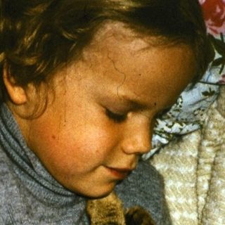 Two children and a cat resting together.