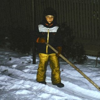 Person shoveling snow at night in winter.