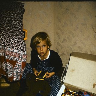 Child playing with open LEGO brick box.