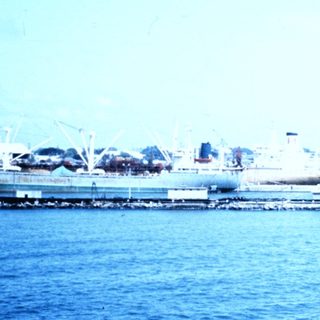 Port area with ships, docks, and industrial waterfront.