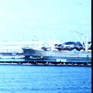 Coastal port area with industrial buildings and waterfront.