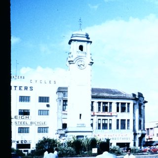 Busy urban street scene with clock tower building.