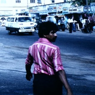 Busy urban street scene with clock tower building.