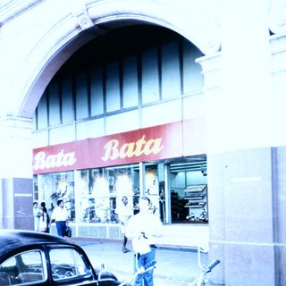 Vintage Bata shoe store with motorcycles parked outside.