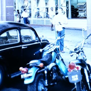Vintage Bata shoe store with motorcycles parked outside.