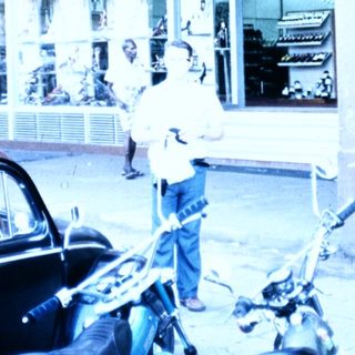 Vintage Bata shoe store with motorcycles parked outside.