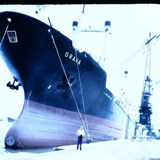 Large cargo ship named "Oraya" docked at port.