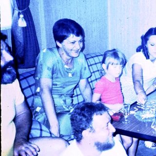 Family gathering around a table indoors.