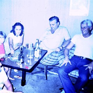Family gathering around a table indoors.