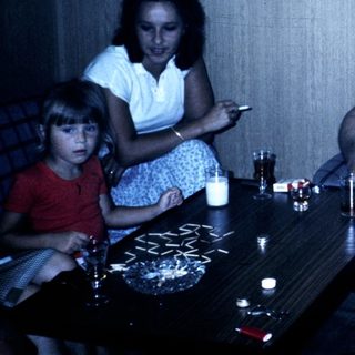 Family gathering indoors in casual summer attire.