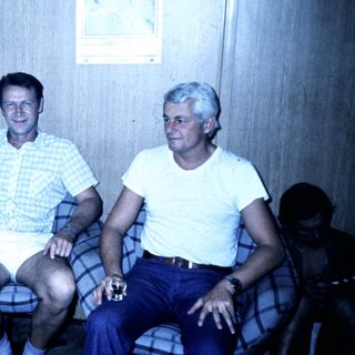 Family gathering indoors in casual summer attire.