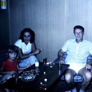 Family gathering indoors in casual summer attire.