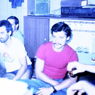 Four men sitting indoors in casual attire.