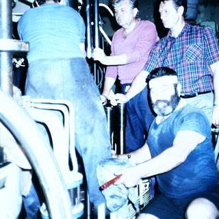 Industrial setting with workers operating machinery.