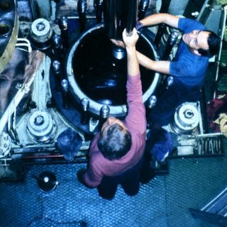 Technicians performing maintenance on aircraft engine.