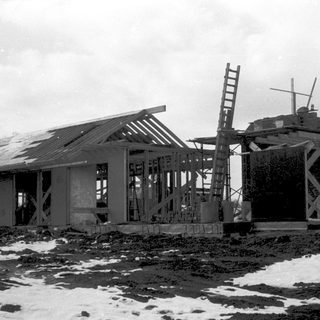 A partially destroyed building under construction in snowy conditions.