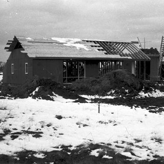House under construction in snowy landscape.