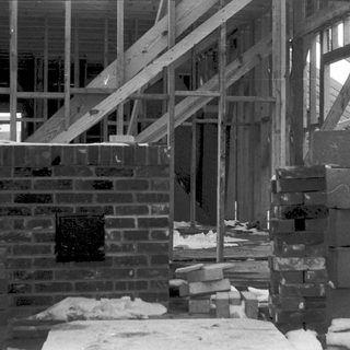 Frame-up construction with brick foundation and lumber framing.