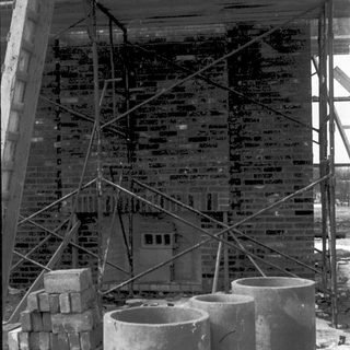 Construction site with brick wall under scaffolding.
