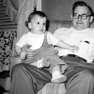 A man holding a young child indoors.