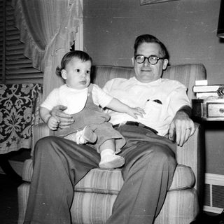 A man holding a young child indoors.