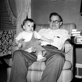 A man holding a young child indoors.