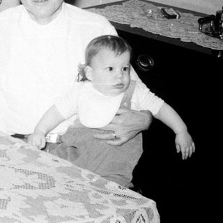 Family gathering celebrating a birthday with cake.
