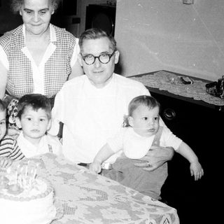 Family gathering celebrating a birthday with cake.