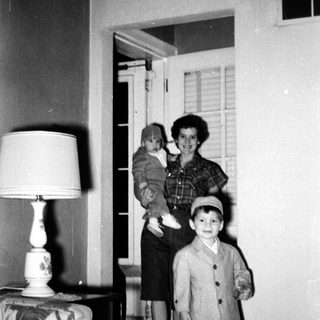 Family portrait in 1950s-style home interior.