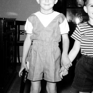 Two young boys posing indoors in 1950s-style clothing.