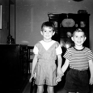 Two young boys posing indoors in 1950s-style clothing.