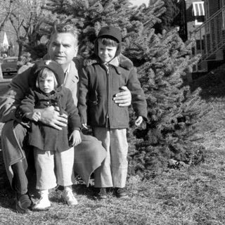Family portrait by vintage cars, 1950s–60s.