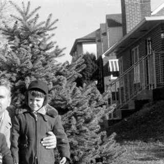Family portrait by vintage cars, 1950s–60s.