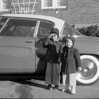 Children by classic car, waving
