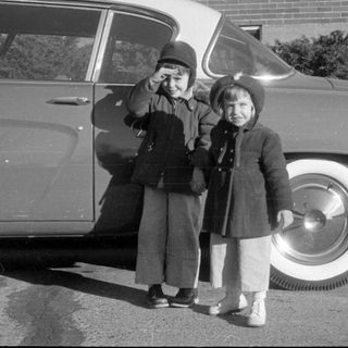Children by classic car, waving