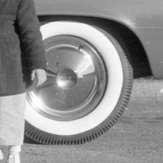 Children by classic car, waving
