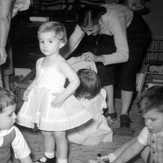 Children and women in a domestic indoor setting.