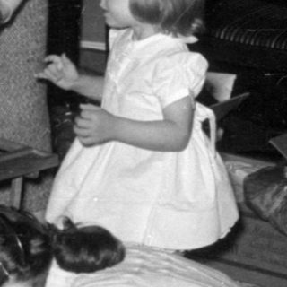 Family gathering around a Christmas tree opening gifts.