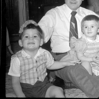 Family portrait in a living room with brick fireplace.