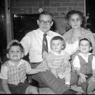 Family portrait in a living room with brick fireplace.