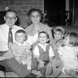 Family portrait in a living room with brick fireplace.