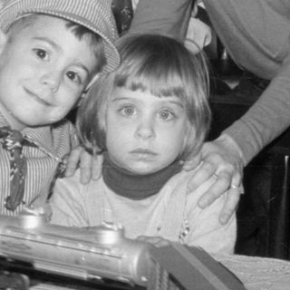 Family posing with model trains and Christmas tree.