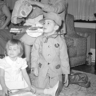 Three children in formal wear on a carpeted floor.