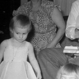 Three children in formal wear on a carpeted floor.