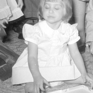Three children in formal wear on a carpeted floor.