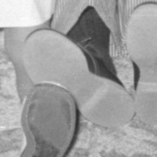 Four children sitting on a carpet indoors.