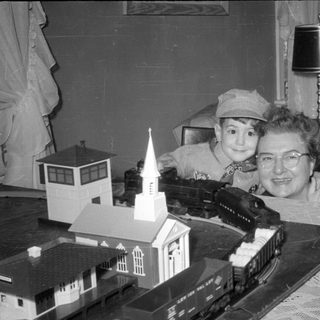 Child and woman with a model train set.