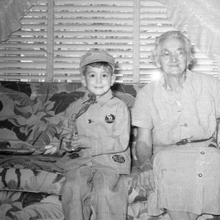 Older woman and two children on a patterned sofa.