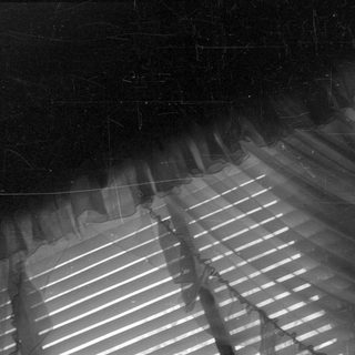 Light filtering through curtains and horizontal slats.